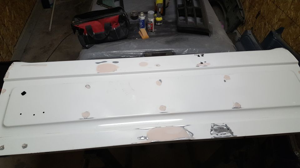 When done grinding the spot may still be somewhat visible.  A very very thin layer of fiberglass should be able to cover up the imperfections.  If you're laying it on thick, then you should probably re-address your weld.  When done, and when paint is applied, a magnet should be able to stick to any part.