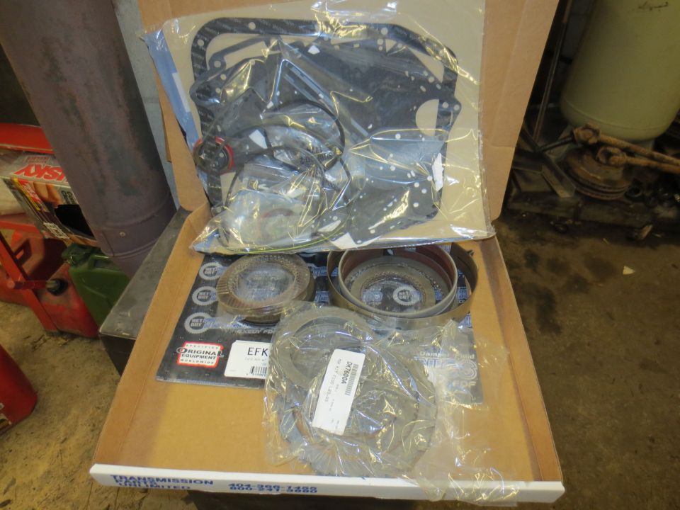 Transmission rebuild kit in a box with gaskets and clutch plates.