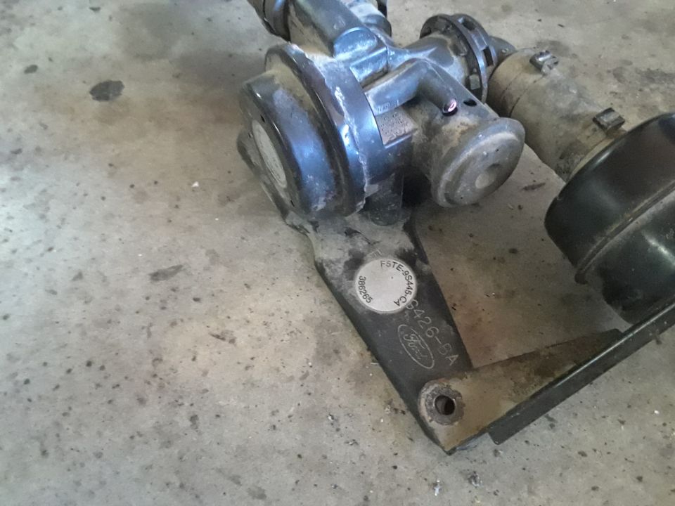 Ford part with part number F5TE-9S445-CA and logo on a bracket.