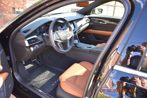 1996 Ford Bronco - The interior of a black car with tan leather seats is shown, focusing on the dashboard, steering wheel, and driver's seat. A timestamp indi…