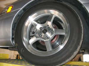 1993 Ford Taurus - Close-up of a silver five-spoke alloy wheel and tire, with a visible performance brake caliper and rotor.