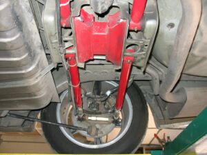 1993 Ford Taurus - A view of the undercarriage reveals red suspension components and the rear wheel assembly.