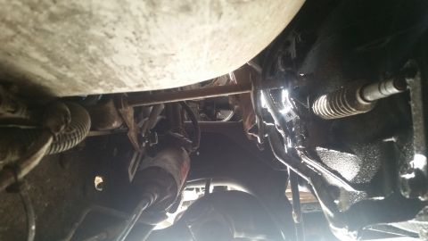 1985 Ford Bronco - A close-up view of the underside of a vehicle, showing mechanical parts and suspension.