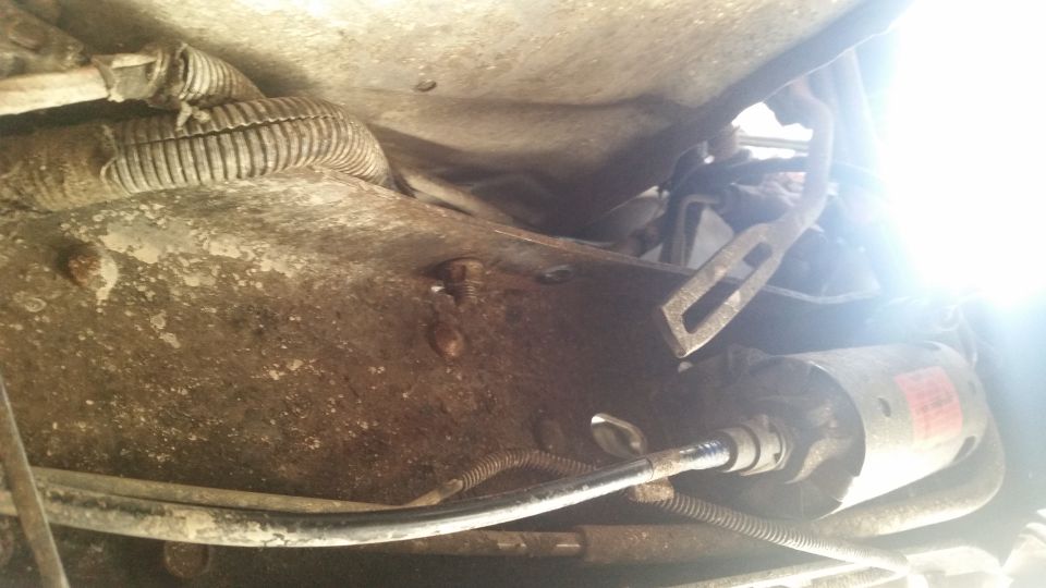 Underside view of starter motor and wiring harness on a vehicle