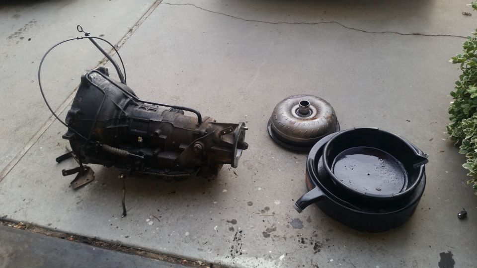 Transmission and torque converter on concrete, with a drain pan