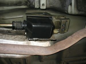 1993 Ford Taurus - Close-up of undercarriage components, including an exhaust pipe and a black housing unit.