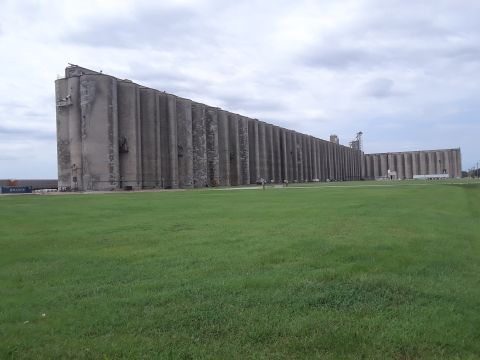 1994 Ford Bronco - A vast industrial grain elevator complex stretches across the horizon under an overcast sky.