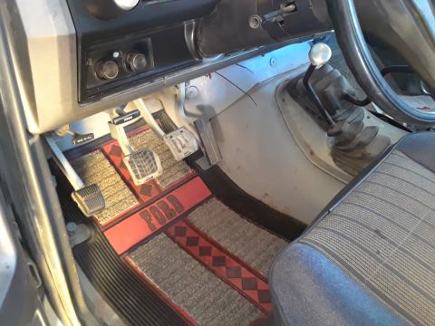 1985 Ford Bronco - Interior view of a 1985 Ford Bronco, highlighting the pedals and custom floor mats.