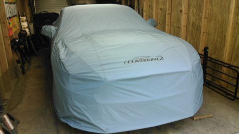 2017 Ford Mustang - A car is completely covered by a light blue car cover, obscuring its make and model. The cover has the 'Coverking' logo visible.