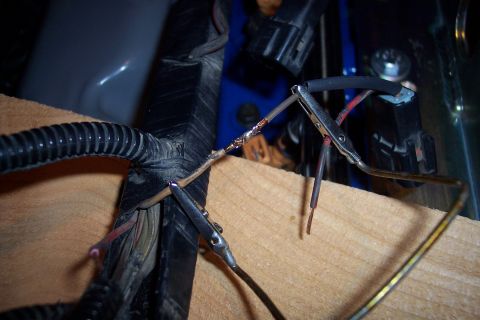 1995 Ford Bronco - Close-up of a wiring harness repair, showing wires being held by alligator clips.