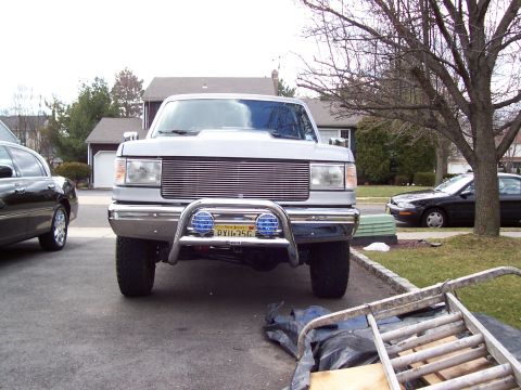 1990 Ford Bronco - This Ford F-150 features a prominent chrome grille and a brush guard with auxiliary lights.