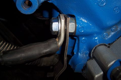 1995 Ford Bronco - A close-up view shows a bolt and bracket assembly on a blue engine block.