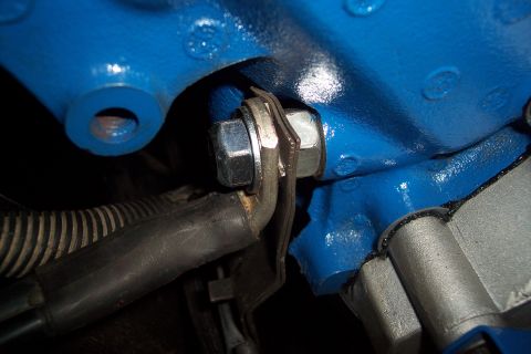 1995 Ford Bronco - Close-up of a blue engine block with a bolt and hose attached. The Supermotors.net logo is visible in the lower right corner.