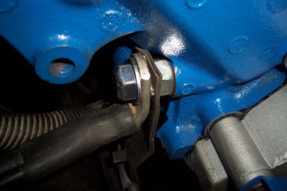 Blue engine block with bolt and hose. Supermotors.net logo visible