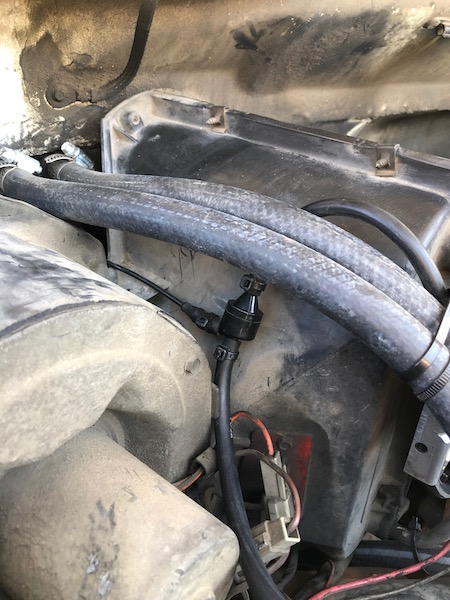 1981 Ford Bronco - Close-up of a fuel filter and hoses in an engine bay.