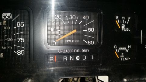 1985 Ford Bronco - Close-up of a vehicle's interior dashboard gauges, including a tachometer and speedometer.