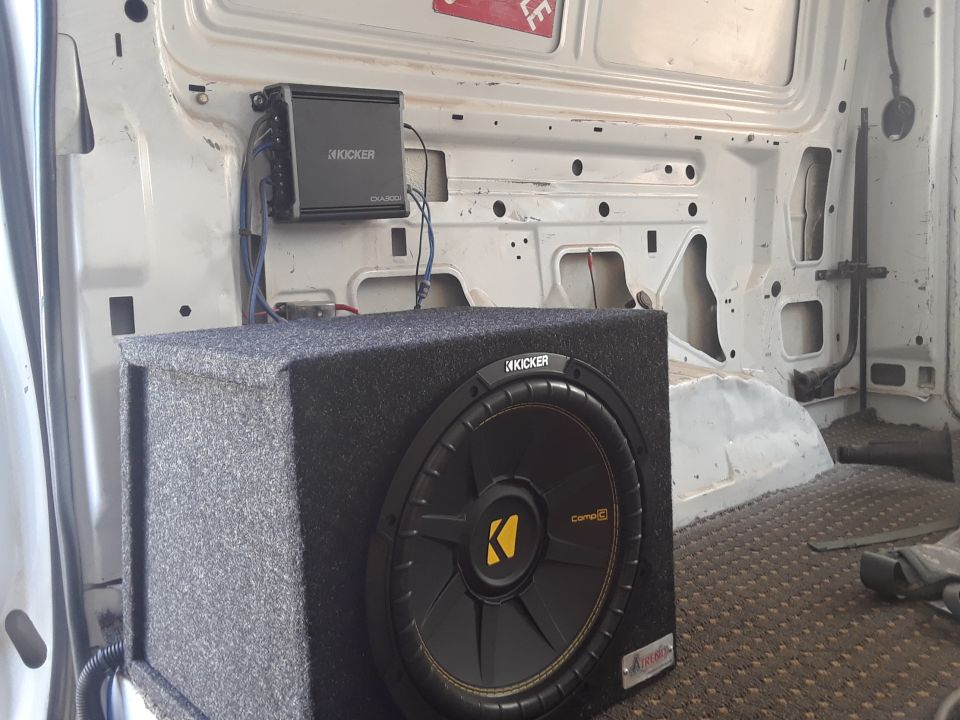 Subwoofer and amplifier mounted inside a white van's cargo area