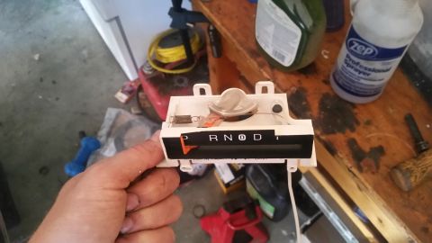 1985 Ford Bronco - Automatic transmission shifter indicator with P R N D markings is held for inspection.