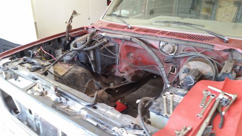 1985 Ford Bronco - Engine bay of a vehicle with tools laid out on a red cloth, suggesting ongoing work.