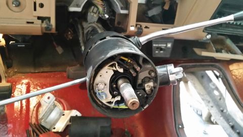1985 Ford Bronco - The steering column of a 1985 Ford Bronco is shown disassembled, revealing internal wiring and mechanical parts.