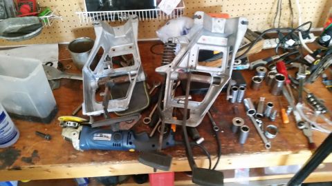 1985 Ford Bronco - Vehicle pedal assemblies and tools laid out on a workbench for repair or modification.