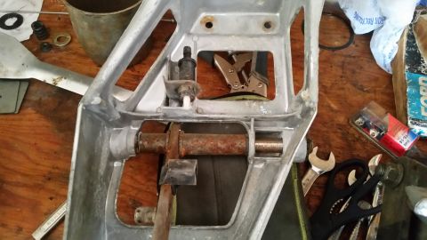 1985 Ford Bronco - A close-up view of a vehicle part assembly with various tools laid out on a workbench.