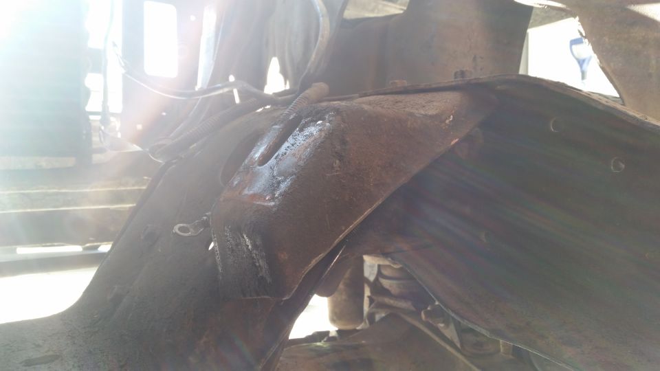 Rusty vehicle frame and suspension parts, close-up view