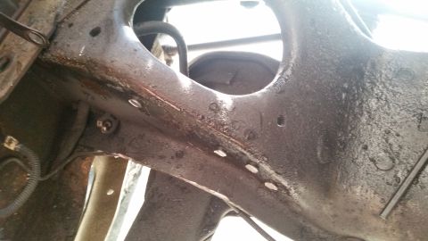 1985 Ford Bronco - Underside view of heavily rusted engine bay components and suspension, showing signs of wear and tear.