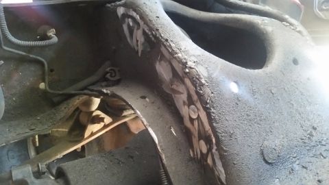 1985 Ford Bronco - Close-up view of the engine bay frame, showing welds and suspension parts, likely during an engine swap.
