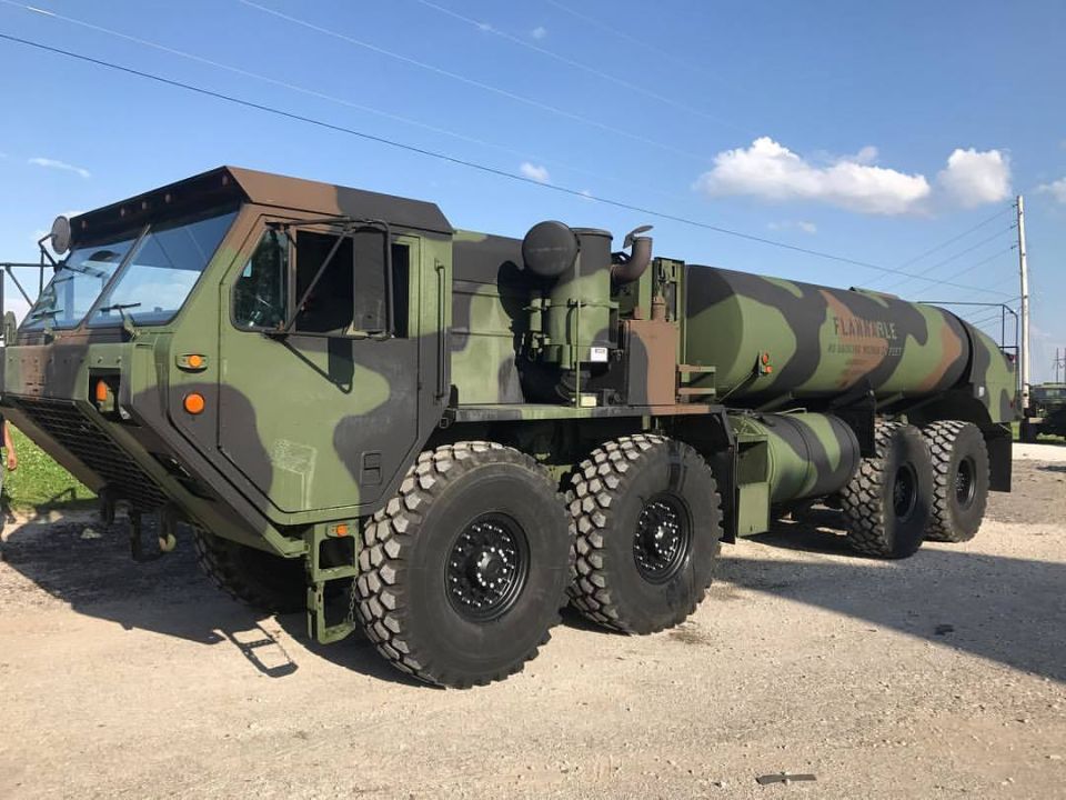 Camouflaged military fuel truck with large off-road tires