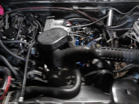 1995 Ford Bronco - Close-up view of a vehicle's engine bay, showing various mechanical parts and wiring.