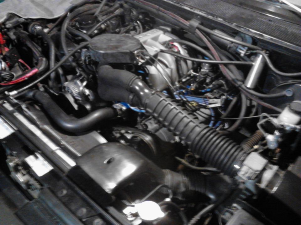 Engine bay with hoses and wiring visible. Watermark reads www.supermotors.net