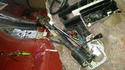 1985 Ford Bronco - Interior view of a disassembled steering column and dashboard components with tools present.