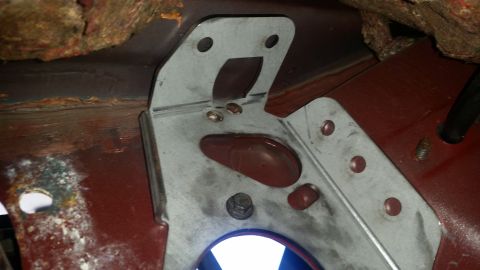 1985 Ford Bronco - Close-up of a metal bracket and floor pan, showing signs of rust and wear.