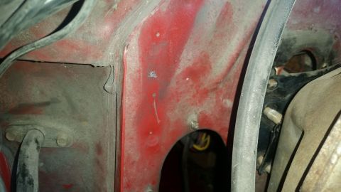 1985 Ford Bronco - Close-up view of the engine bay showing red paint and various hoses and wiring.