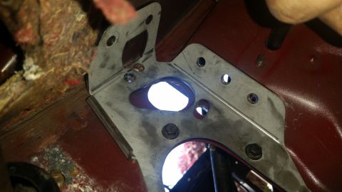 1985 Ford Bronco - Close-up of a metal bracket installed in a vehicle's interior, showing mounting hardware and insulation.