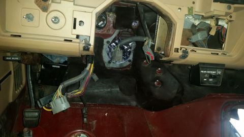 1985 Ford Bronco - The interior of a vehicle shows exposed wiring and dashboard components, suggesting a repair or modification is underway.