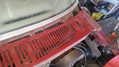 1985 Ford Bronco - A red cowl vent panel is shown in a close-up view, with visible engine parts and a watermark at the bottom.