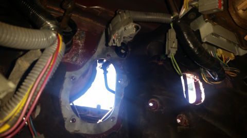 1985 Ford Bronco - Close-up of the vehicle's interior firewall shows exposed wiring harnesses and cutouts for components.