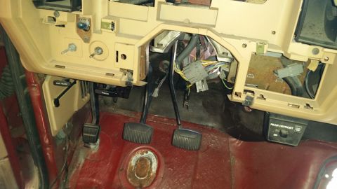 1985 Ford Bronco - Interior view of a vehicle's dashboard and pedals, with exposed wiring and a 'Rear Defrost' switch.