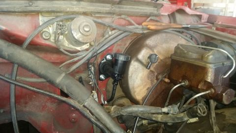 1985 Ford Bronco - Close-up view of the brake master cylinder and brake booster assembly in a vehicle's engine bay.