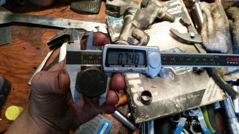 1985 Ford Bronco - A digital caliper is used to measure a bolt, showing a reading of 0.748 inches on the display.