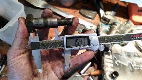 1985 Ford Bronco - A bolt is measured with digital calipers, with a background image of a truck.