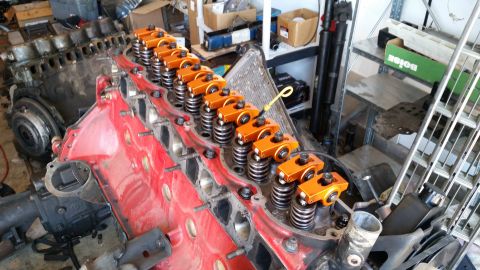 1985 Ford Bronco - Close-up of an engine block assembly, bright orange rocker arms and valve springs.