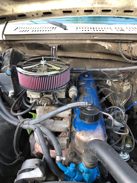 1981 Ford Bronco - Close-up of an engine bay with an aftermarket air filter and blue valve covers.