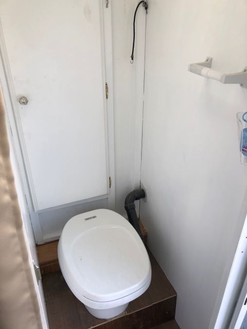 1992 Jeep Wrangler - The interior of a small bathroom features a toilet and a door.