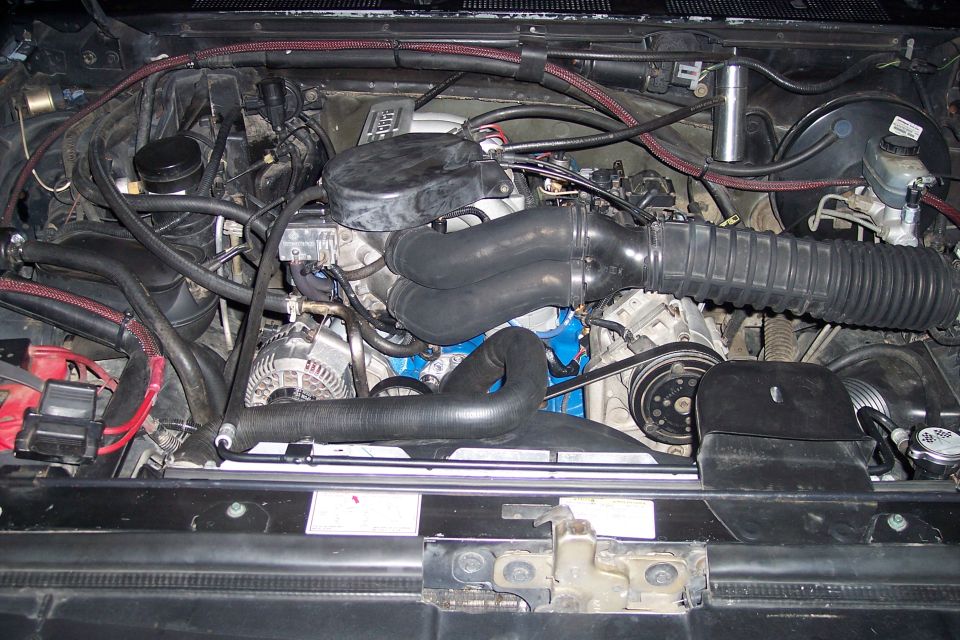 Engine bay of a 1992 Ford Bronco, showing the V8 engine with hoses and belts