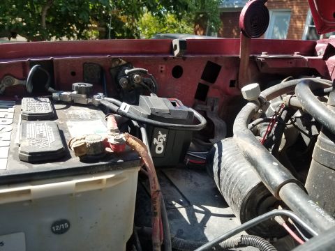 1995 Ford Bronco - This photo shows the battery and some engine bay components of a vehicle, with a focus on the electrical connections.