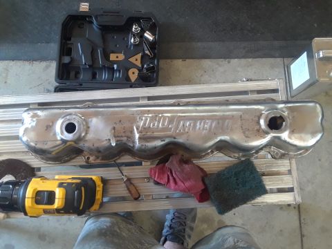 1985 Ford Bronco - A chrome valve cover with 'POWER BY FORD' is shown with tools for cleaning and repair.