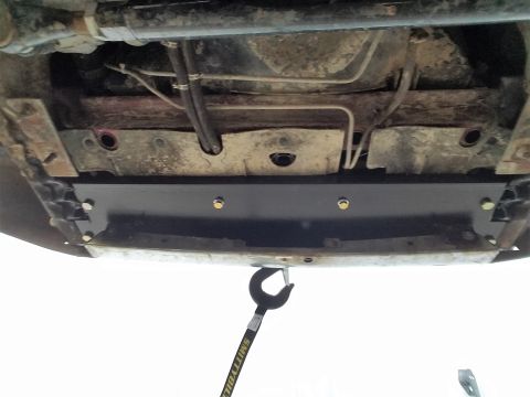 1995 Ford Bronco - A black winch mount plate is visible installed on the undercarriage of a vehicle, with visible hoses and frame components.